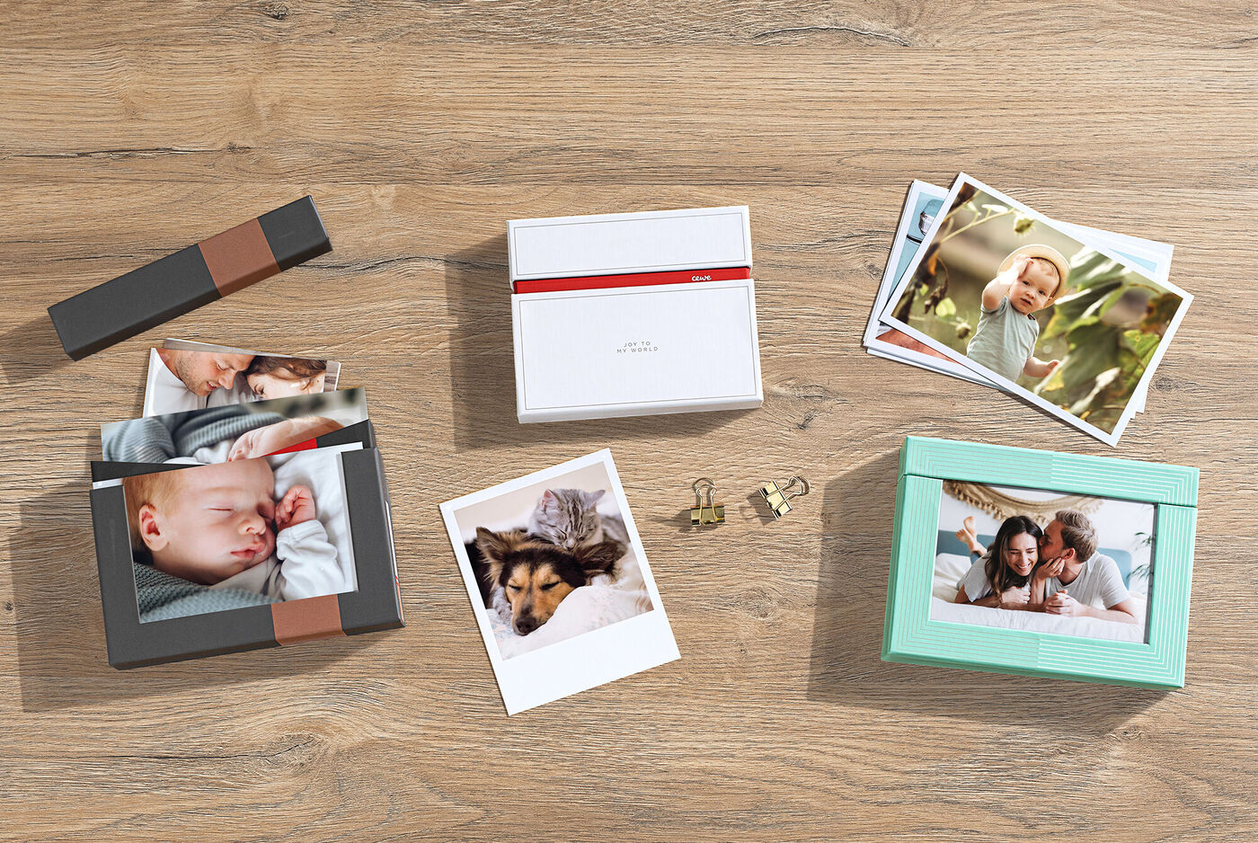 Diverse fotodoosjes met bijhorende fotoafdrukken zijn uitgestald op een houten tafel