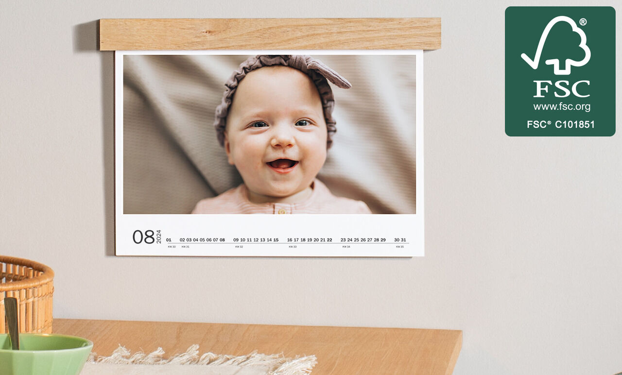 Kalender met schattige foto in moderne, gezellige kamer.