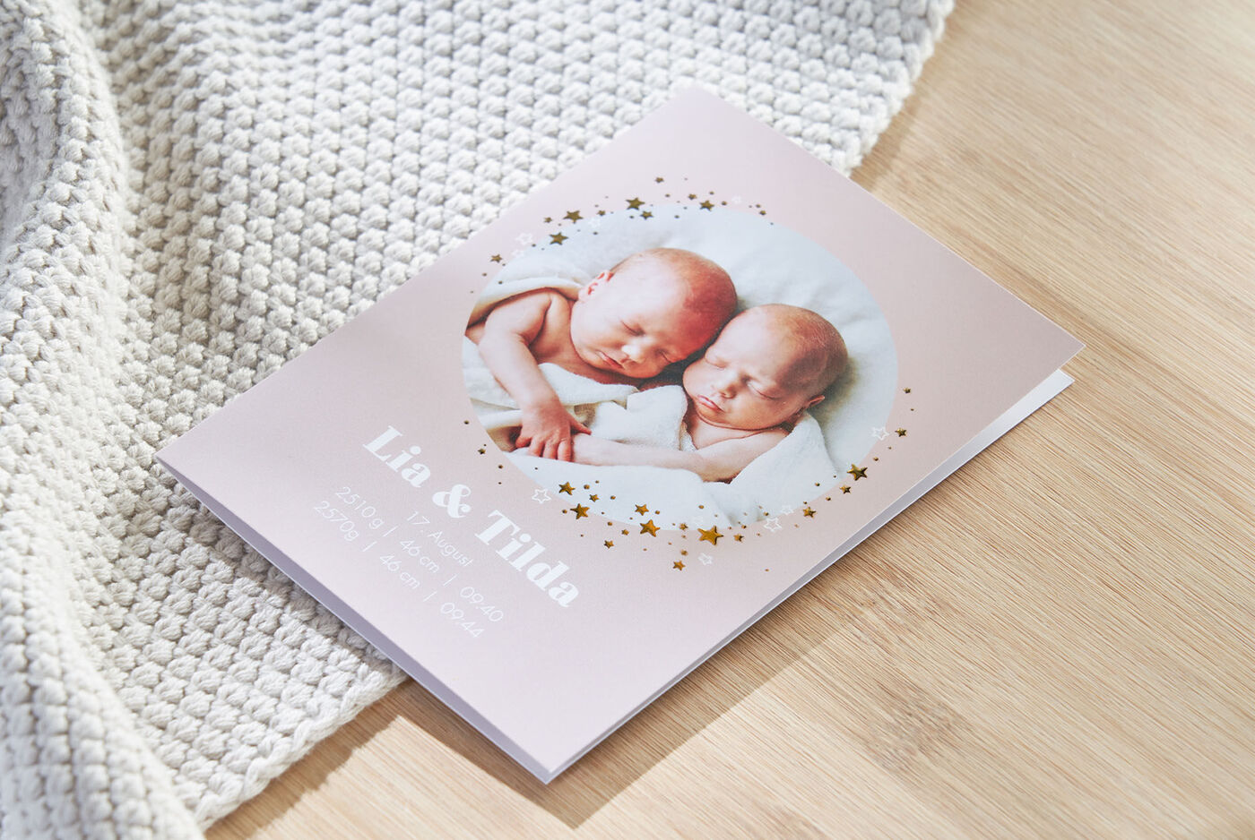 Een subtiel fotoboek met de namen Lia en Tilda op de cover. Het toont slapende tweelingen in een zachte deken.