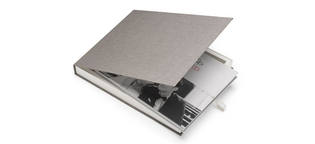 Open CEWE FOTOBUCH met een grijze omslag en afbeeldingen binnenin.