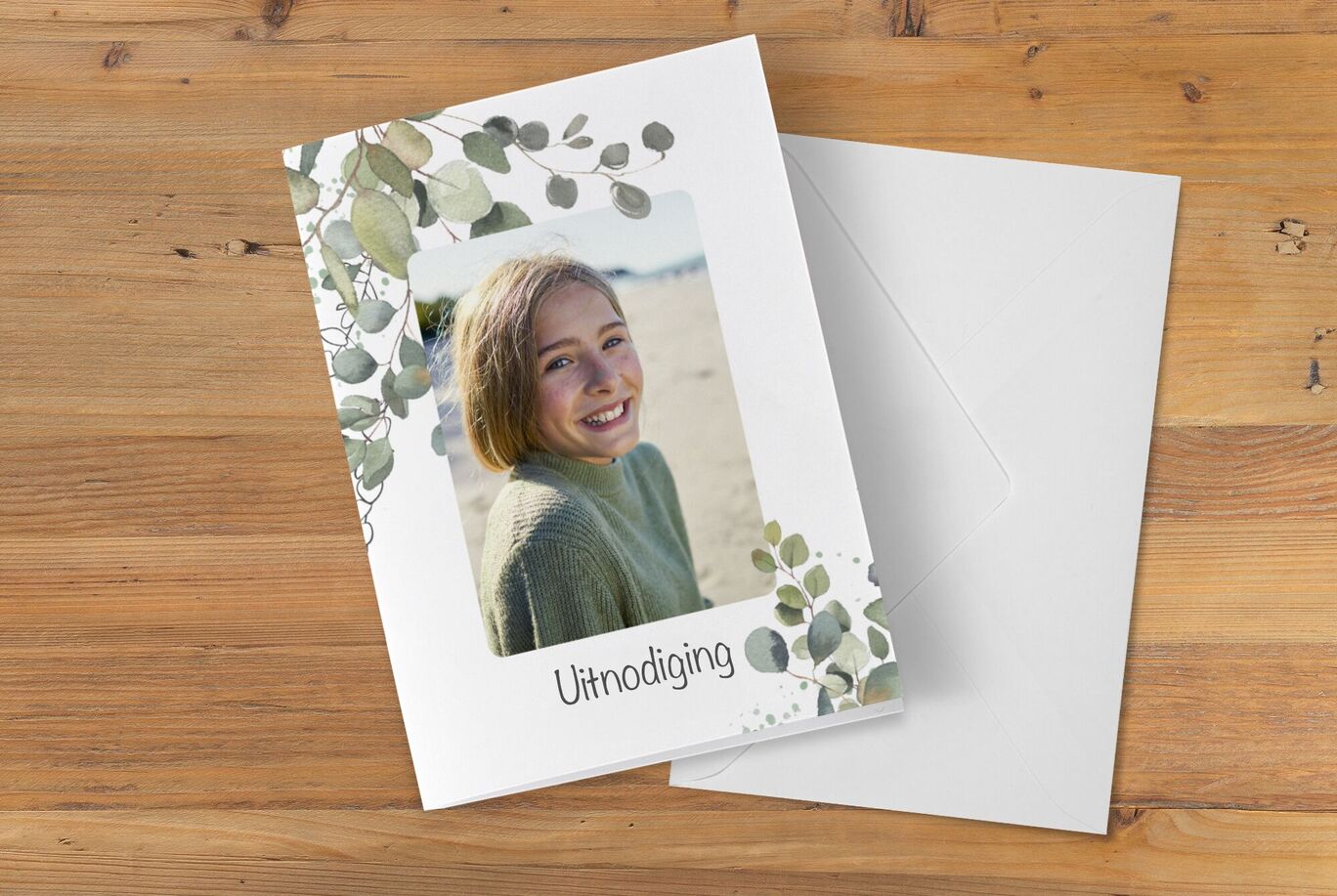 Uitnodigingsontwerp met groen bladerenmotief en persoonlijke foto.