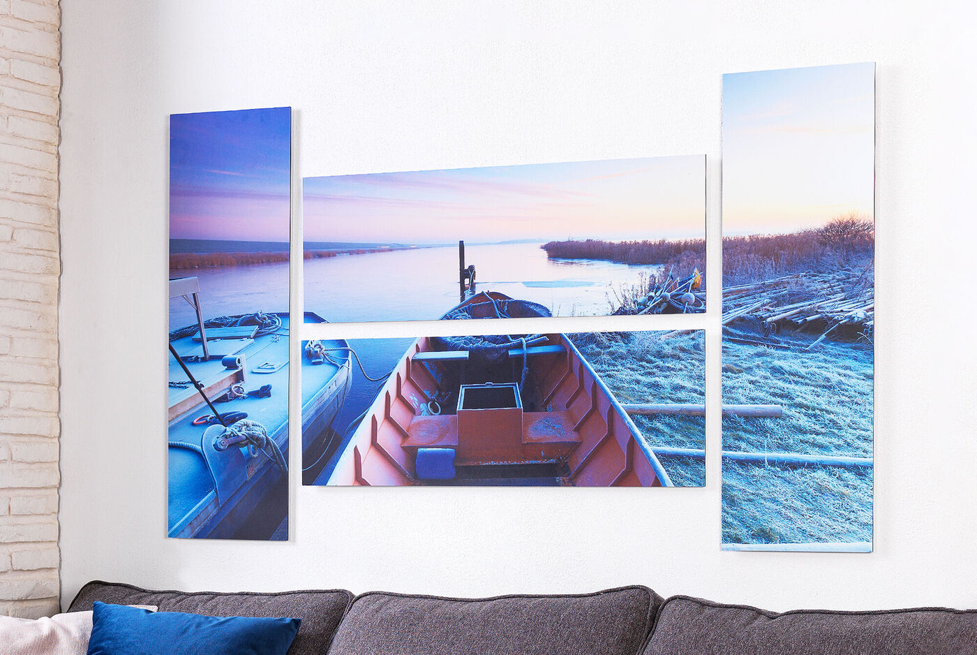 Creatieve wanddecoratie in drie delen met een boot op rustig water bij zonsopgang.