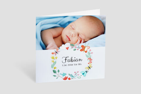 Een schattige baby slaapt vredig in een blauwe deken, omringd door bloemen en vlinders op de kaart.
