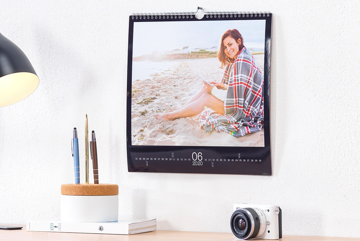 Een mooie fotokalender toont iemand die leest op het strand.