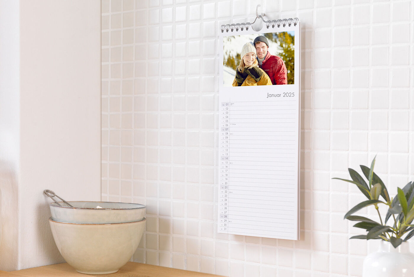 Kalender met een foto van twee lachende personen in een winterse omgeving
