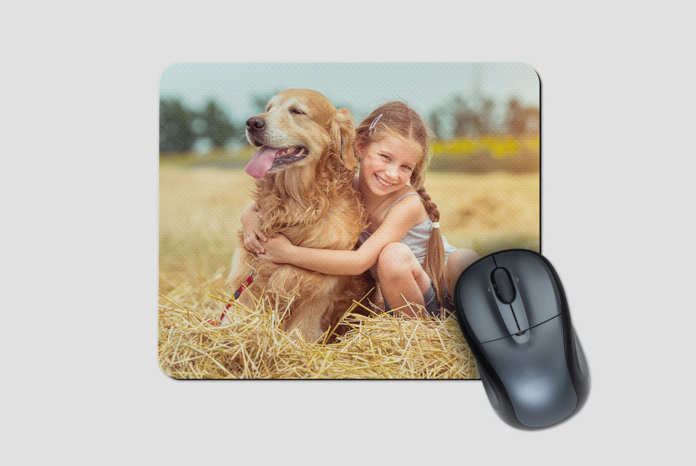 Een meisje knuffelt haar schattige hond op een veld met stro. Ze genieten van een moment van samenhorigheid.
