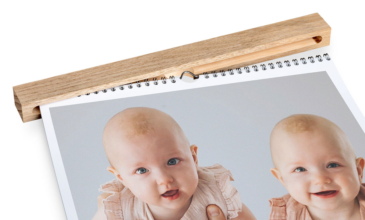 Twee baby's die vriendelijk glimlachen, afgebeeld op een fotokalender.
