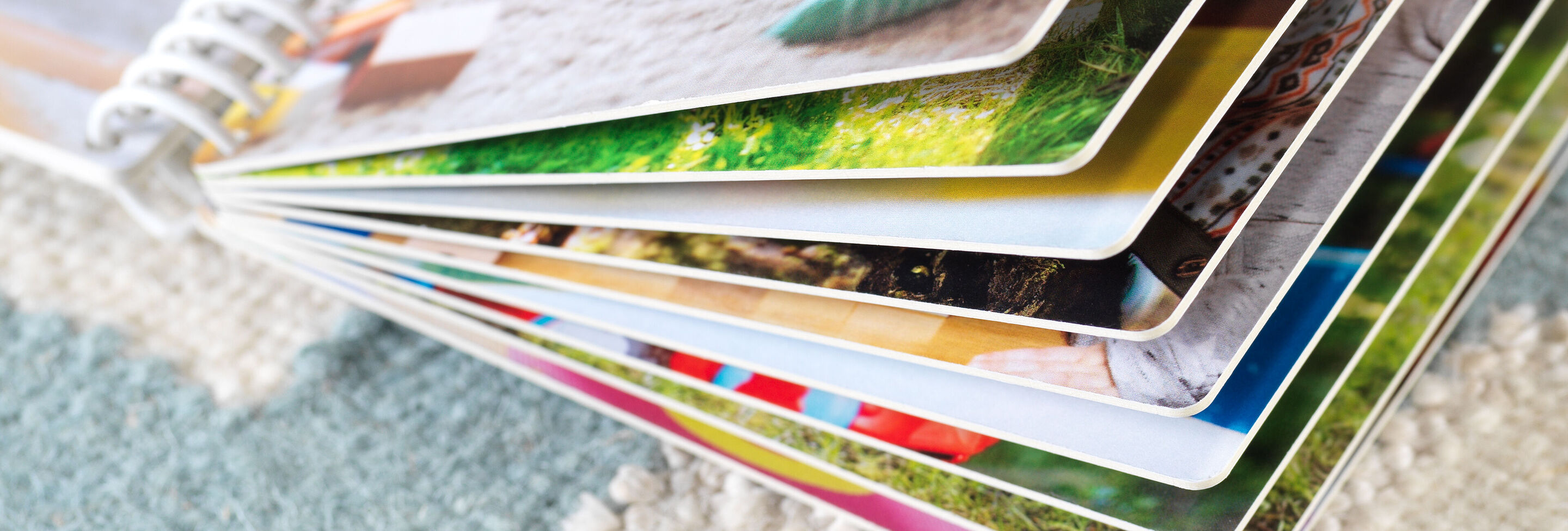 Detailfoto van een geopend fotoboek met kleurrijke pagina's.