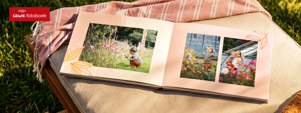 Geopend fotoboek met een meisje tussen de bloemen.