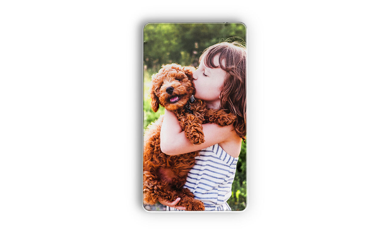 Een blije puppy wordt geknuffeld door een kind.