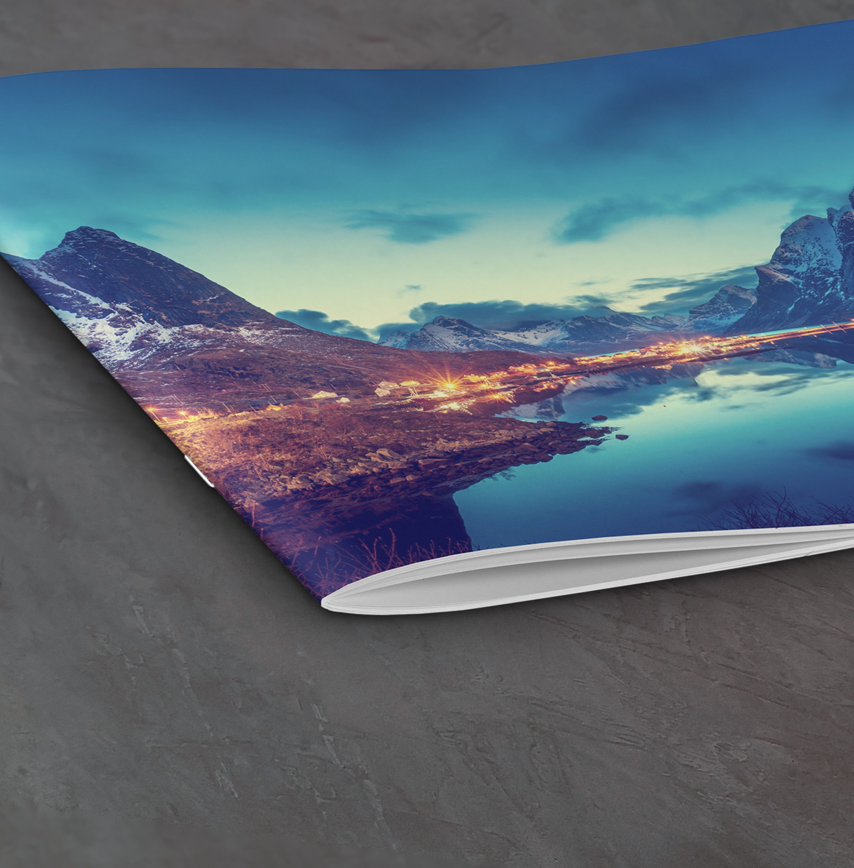 Een open CEWE fotoboek toont een berglandschap, een rustig meer en blauwe lucht.