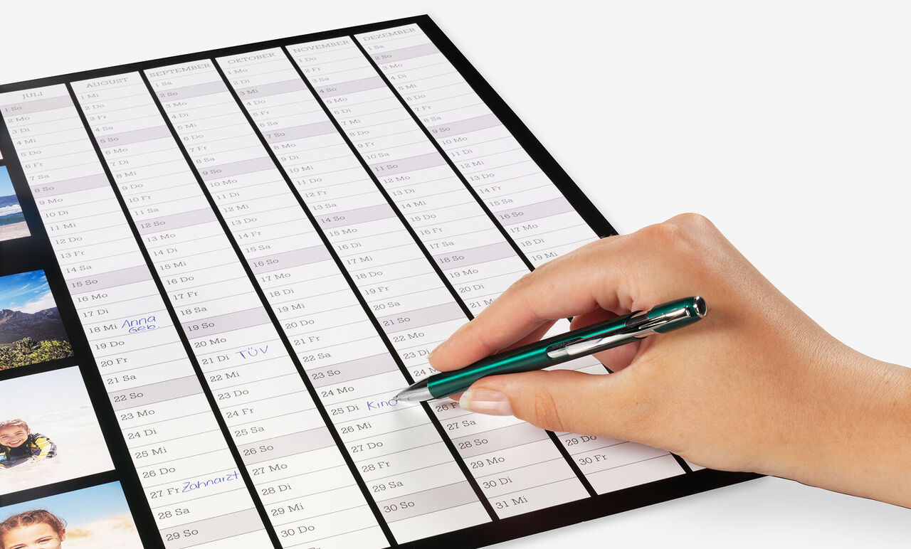 Hand schrijft op een kalender met een pen en toont een planningsonderdeel.