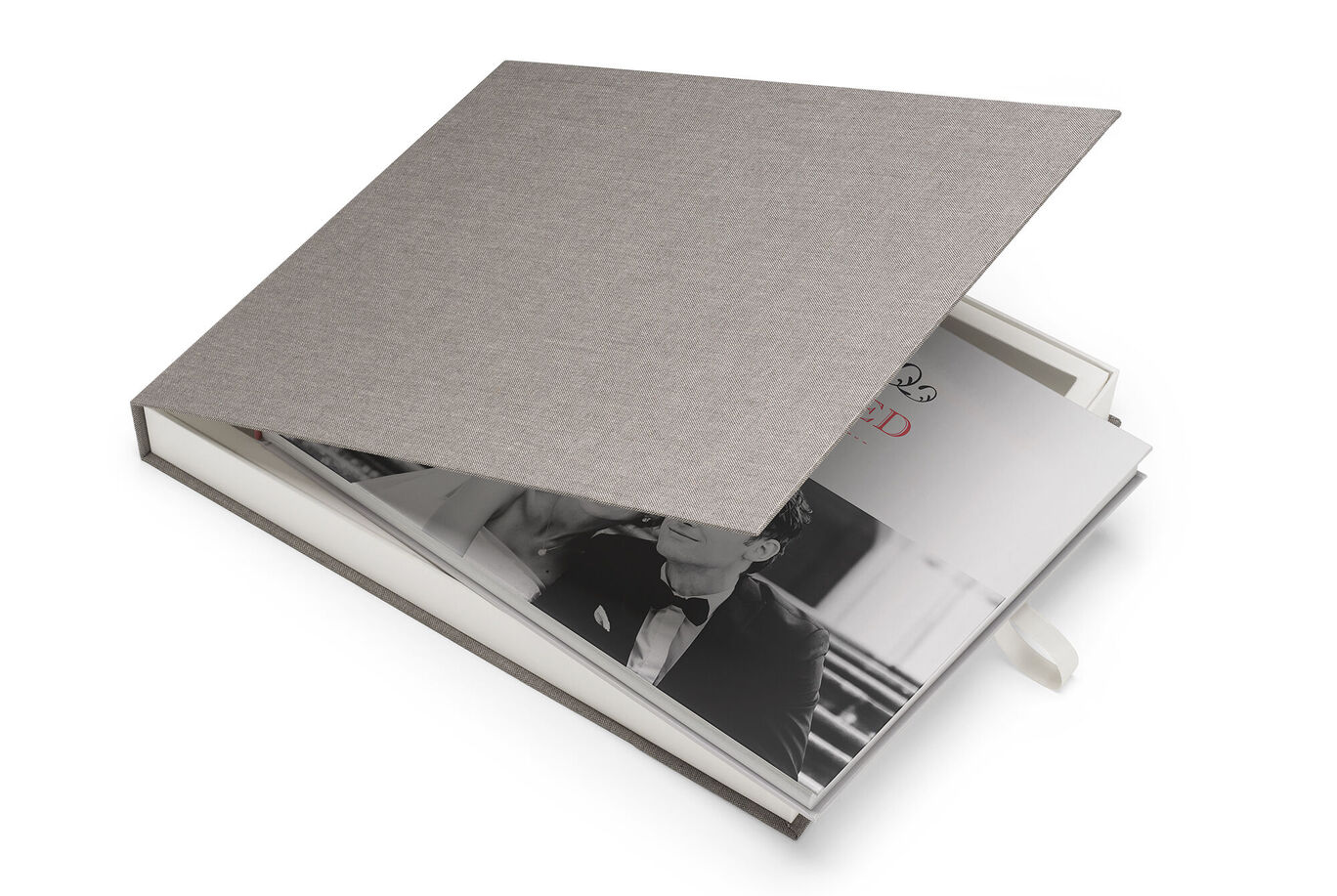 Een geopend CEWE FOTBOEK met een elegante grijze hardcover en een romantische zwart-wit foto aan de binnenkant