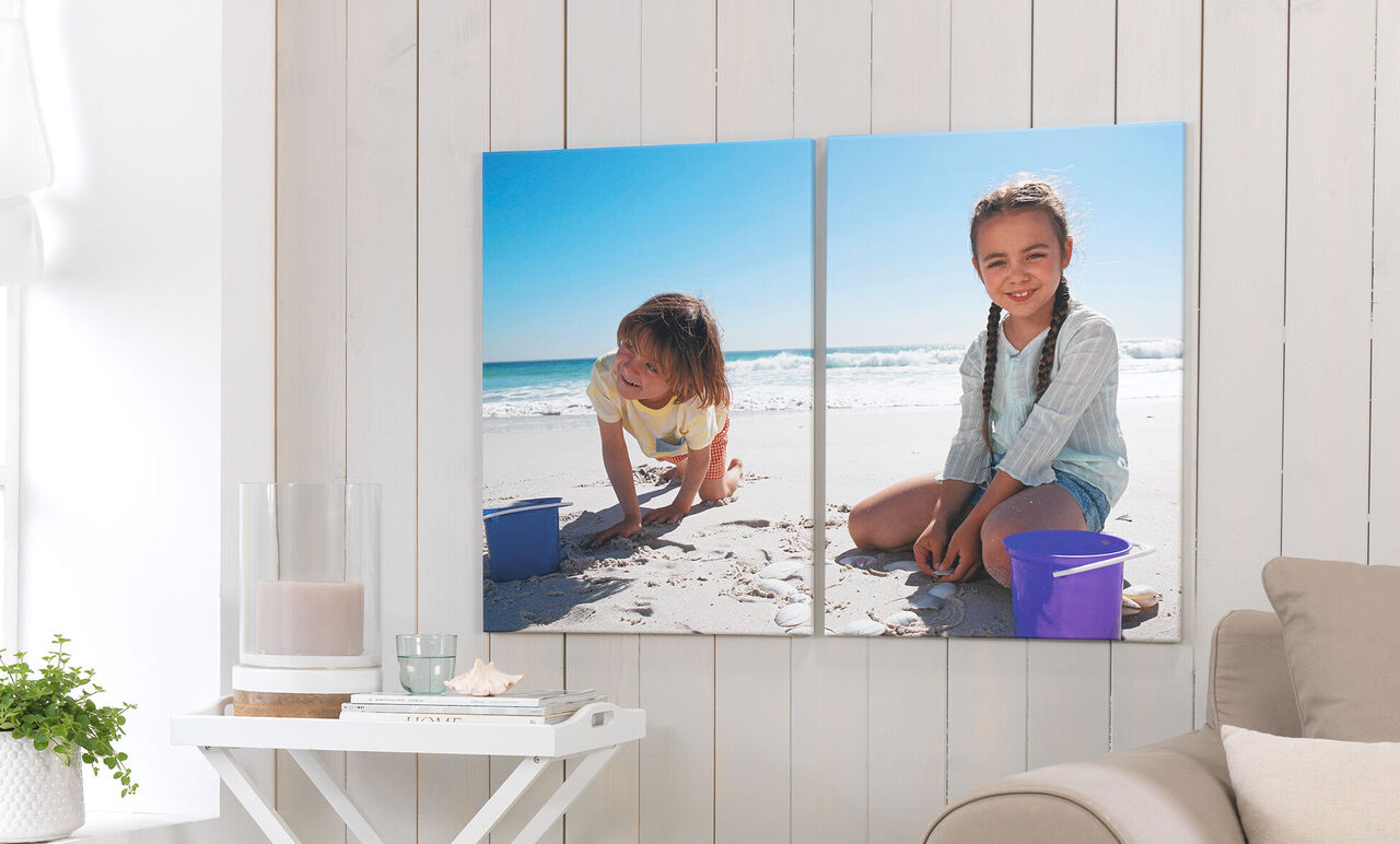 Twee kinderen spelen op het strand met zand en emmers