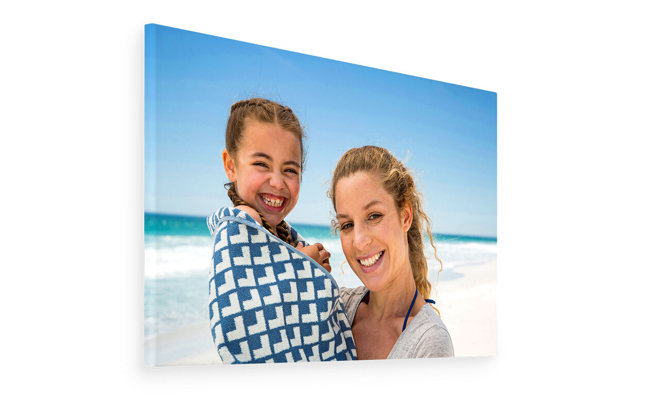 Twee mensen op het strand, een draagt een gedessineerde doek.