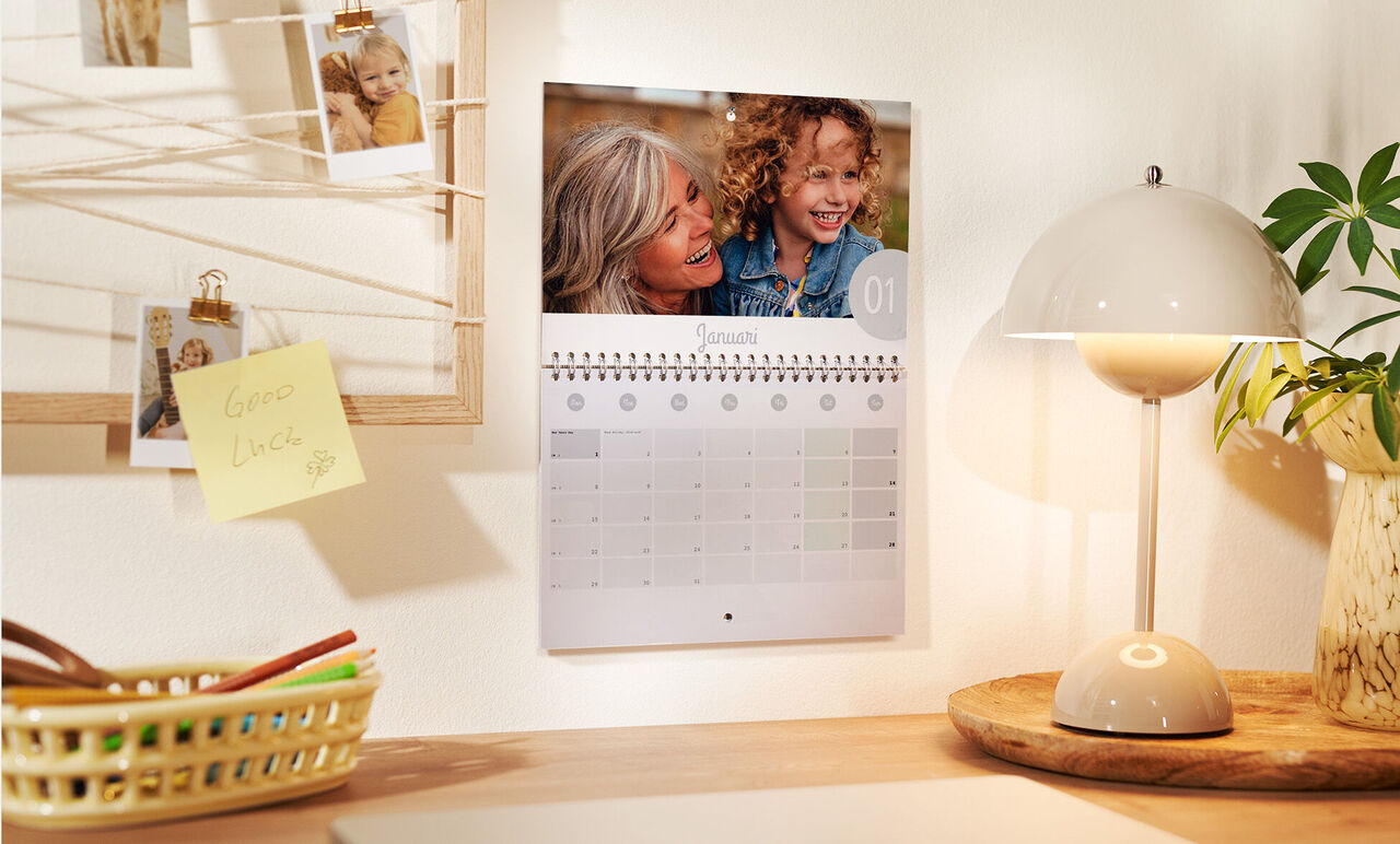 Een wandkalender met persoonlijke foto's en een helder ontwerp. Een liefdevol ingerichte ruimte.