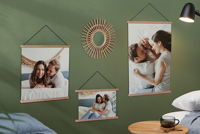 Twee wanddecoraties met blije koppels in een knusse slaapkamer, omringd door zacht groen en warm licht.