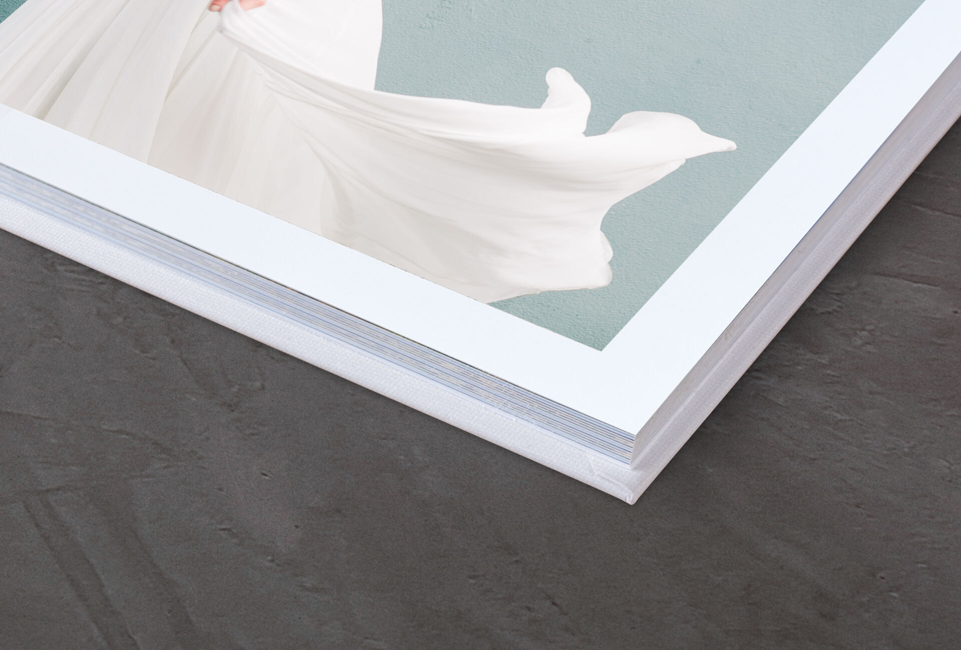 Detailopname van een CEWE FOTOBOEK met een elegant witte kaft en subtiele achtergrond