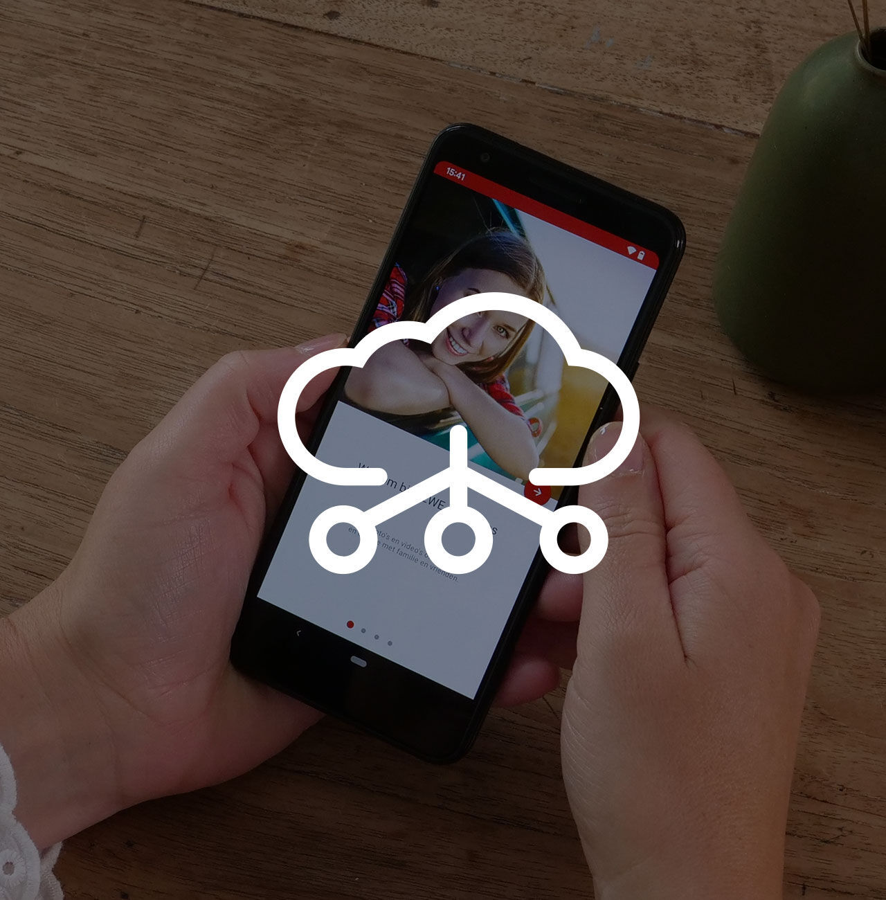 Een persoon houdt een smartphone vast met daarop een grafische weergave van een cloudopslag-app.