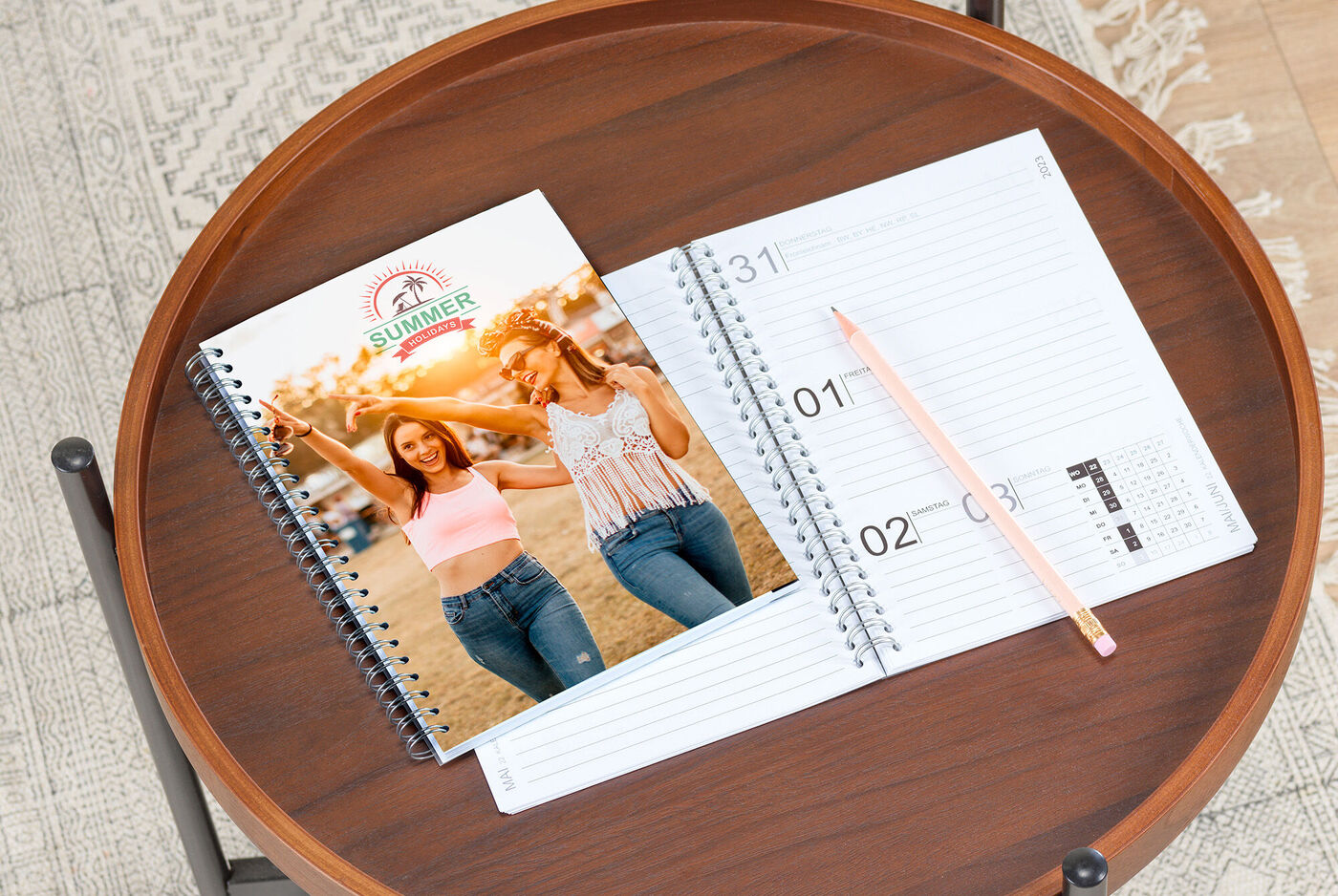 Een CEWE fotoboek op een tafel naast een leeg notitieboek en een potlood
