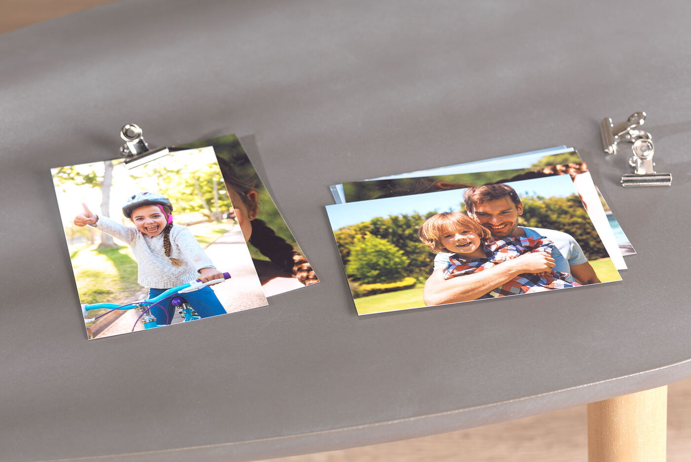Kleurrijke foto's op een tafel, waaronder een kind op een fiets en een volwassene met een kind op de arm.