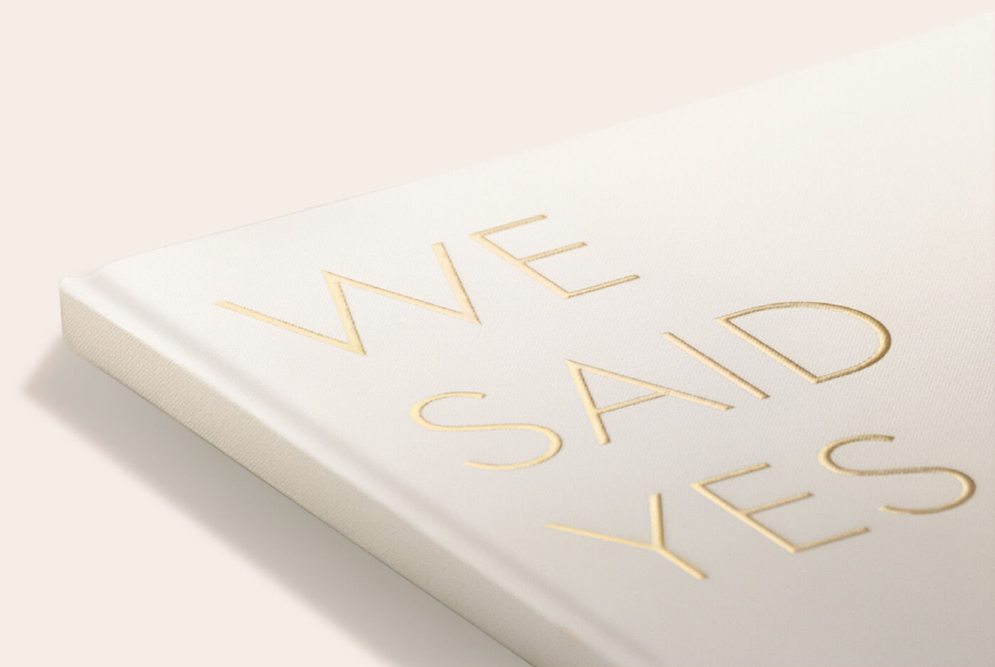 Fotoboek met witte cover en goudkleurige letters “WE SAID YES”.