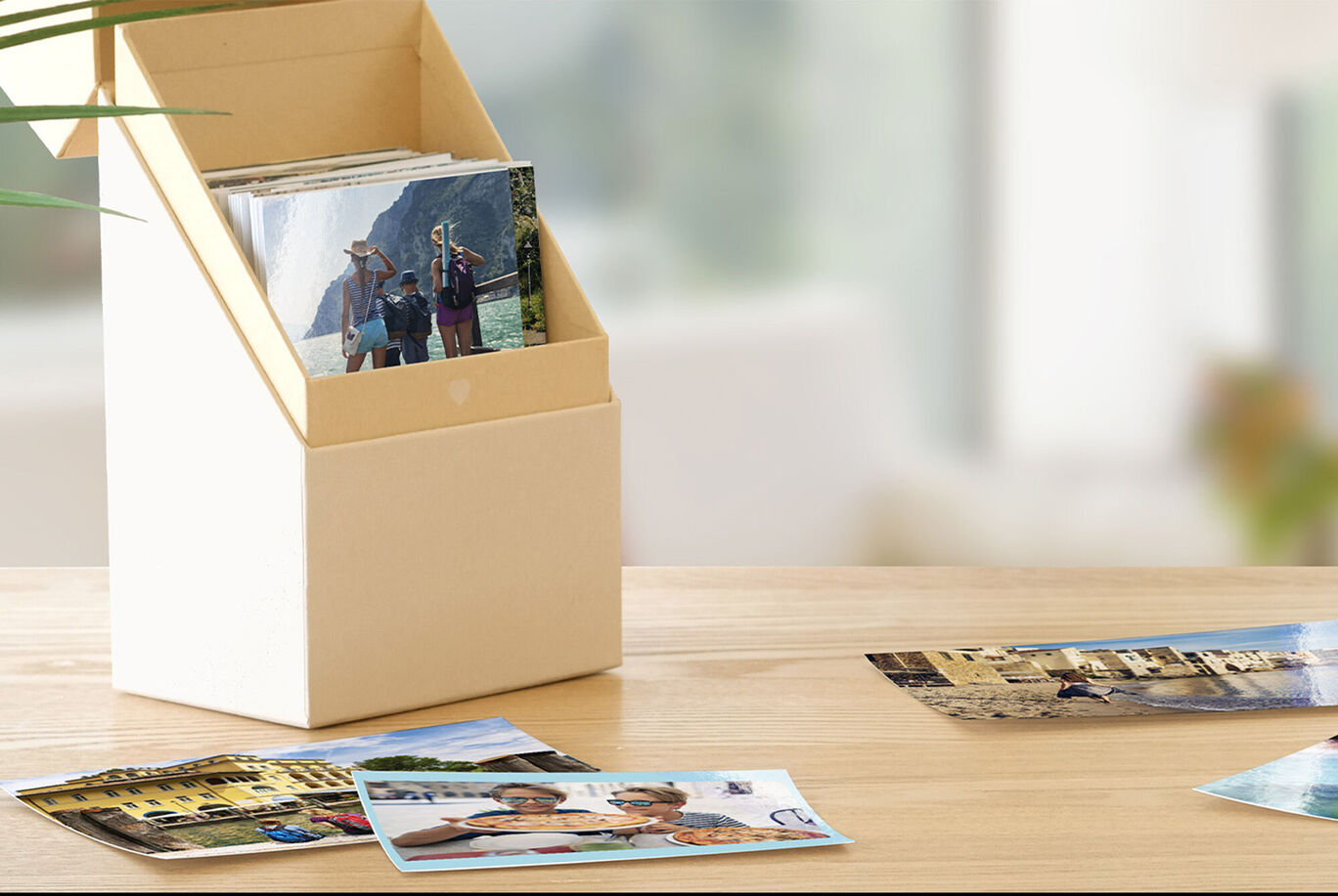 Een decoratieve doos met foto's en enkele afbeeldingen die op een tafel op de voorgrond liggen.