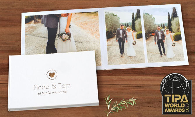 Een prachtig fotoboek van Anna en Tom, liggend op een tafel. Het toont hun bruiloft met liefdevolle momenten en een TIPA World Awards 2020 trofee.