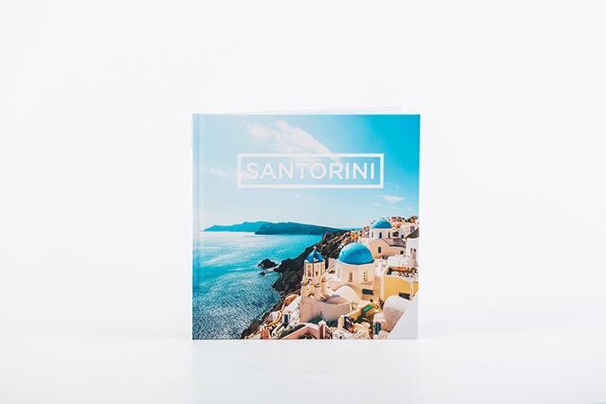 Mooi fotoboek met blauwe kust en Santorini-skyline
