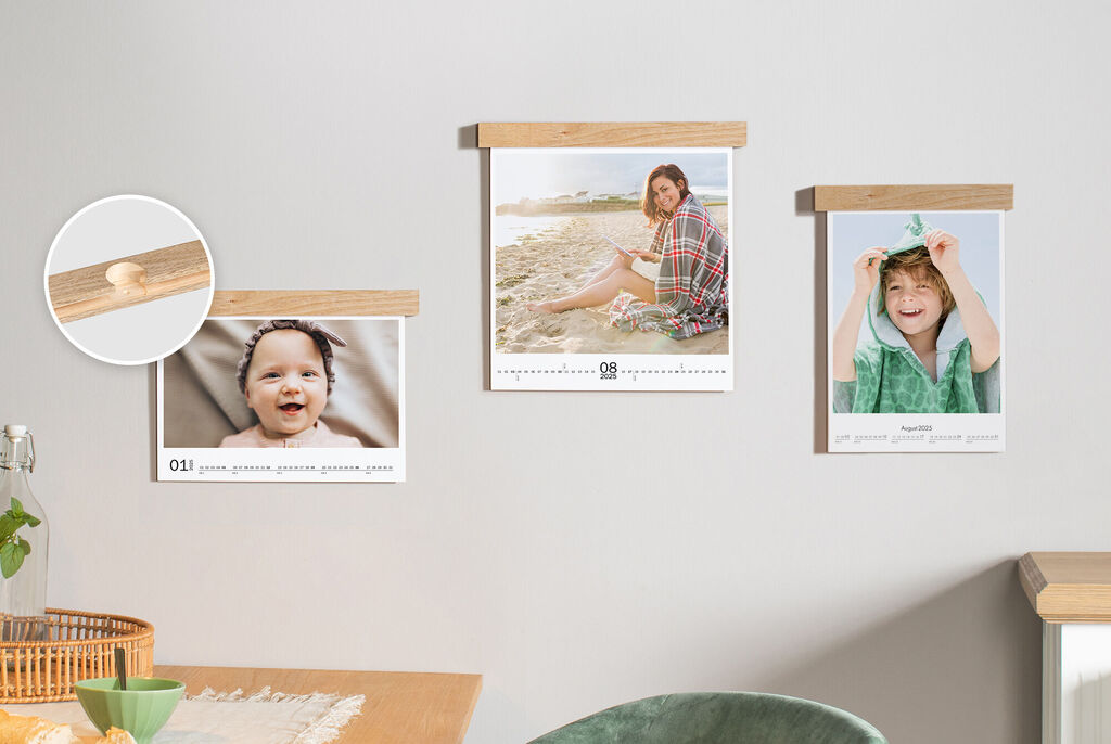 Drie fotokalenders met houtelementen aan de muur, een toont een persoon op het strand, een ander een kind met handdoek.