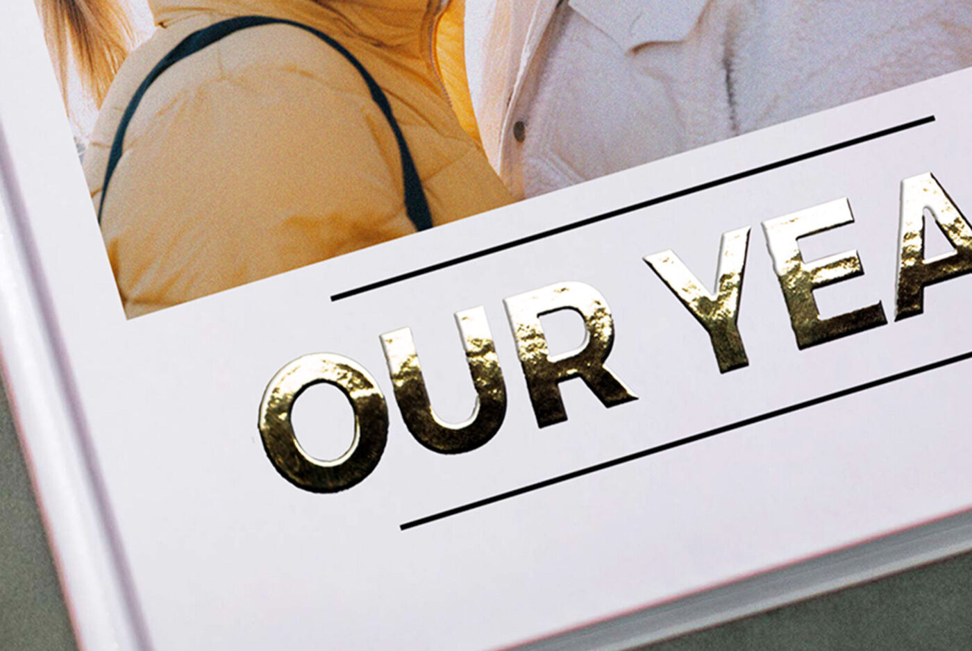 Fotoboek met cover en goudfolie letters “OUR YEAR”, close-up.