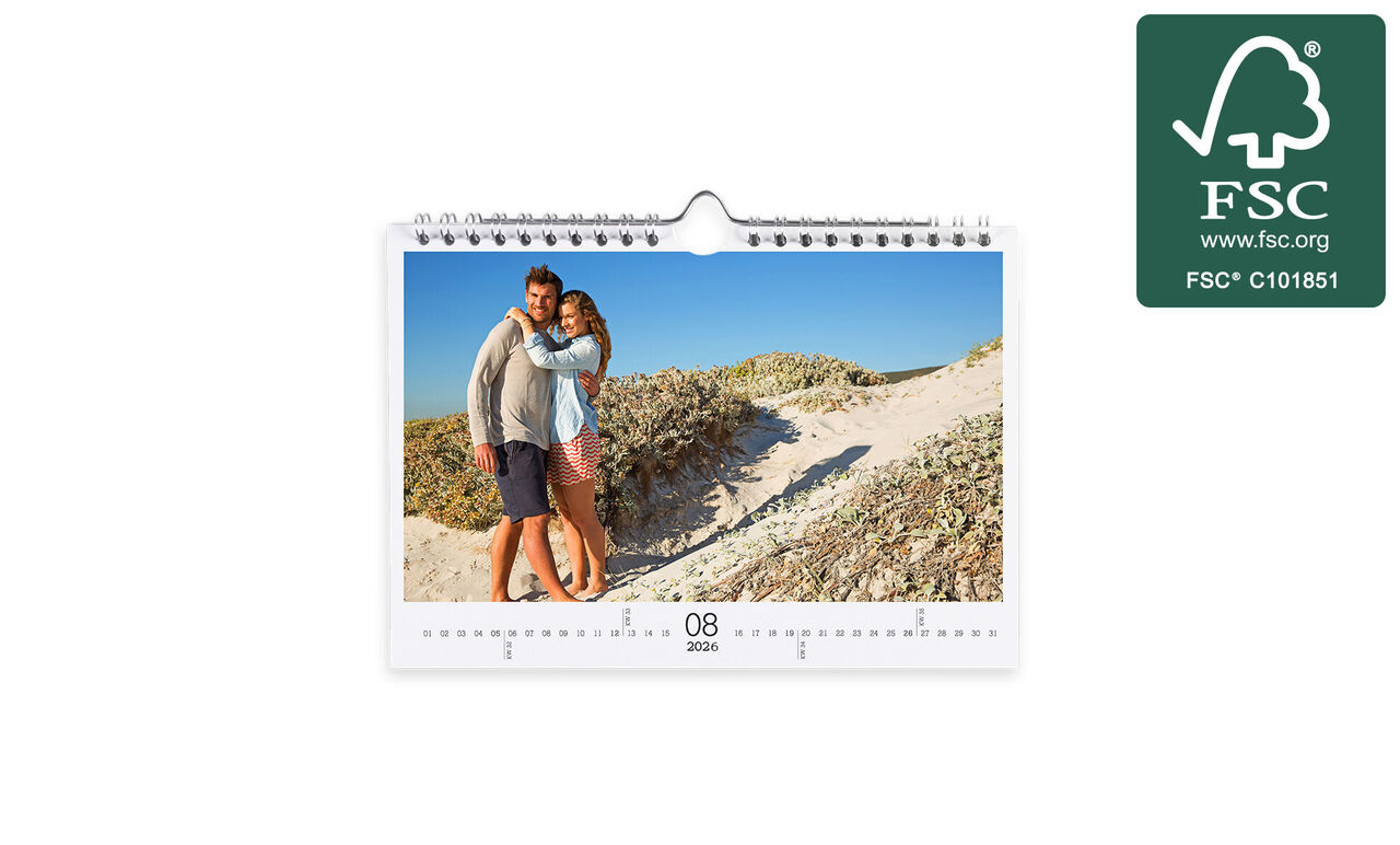 Liefdevol stel poseert bij een strand in een fotokalender.