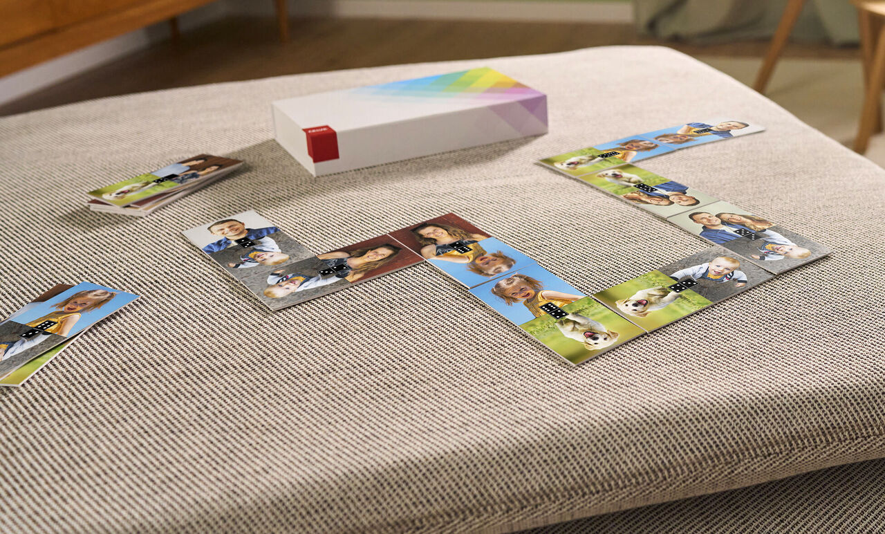 Een stapel fotoboeken met beeldkaarten op een tafel, omringd door foto's van mensen en dieren.