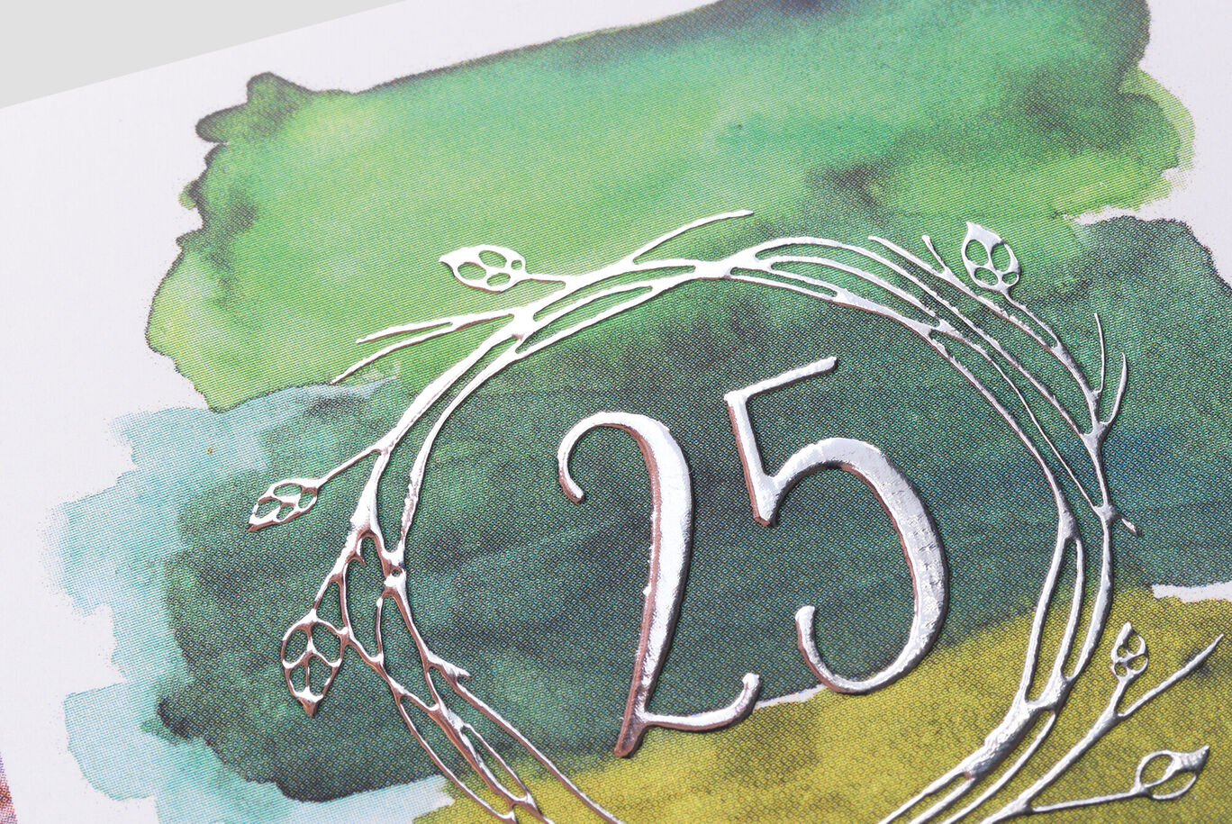 Een creatief ontwerp toont het nummer 25 in een stijlvolle krans op een kleurrijke aquarel achtergrond.