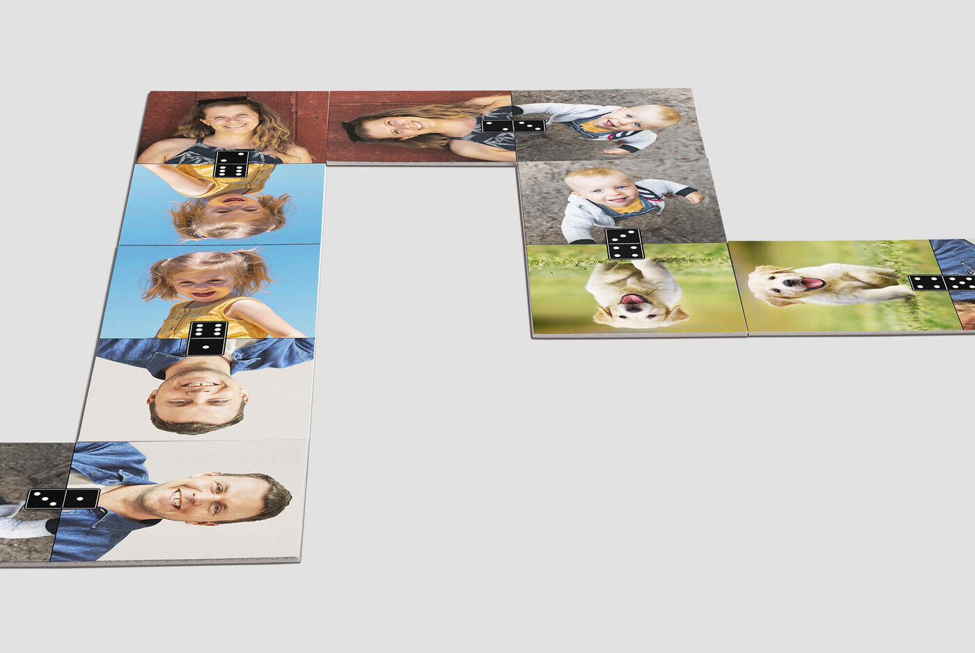 Een creatieve opstelling van fotoblokken met vrolijke gezichten van mensen en een hond. De blokken tonen geluksmomenten.