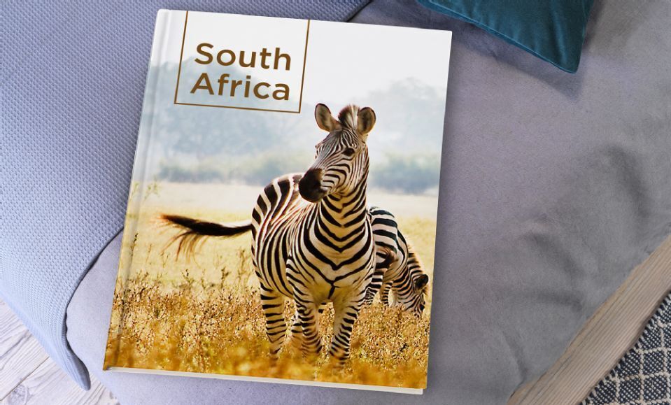Zebra's op een veld in Zuid-Afrikaans gebied, idyllische fotoboekcover met het opschrift 'South Africa'.