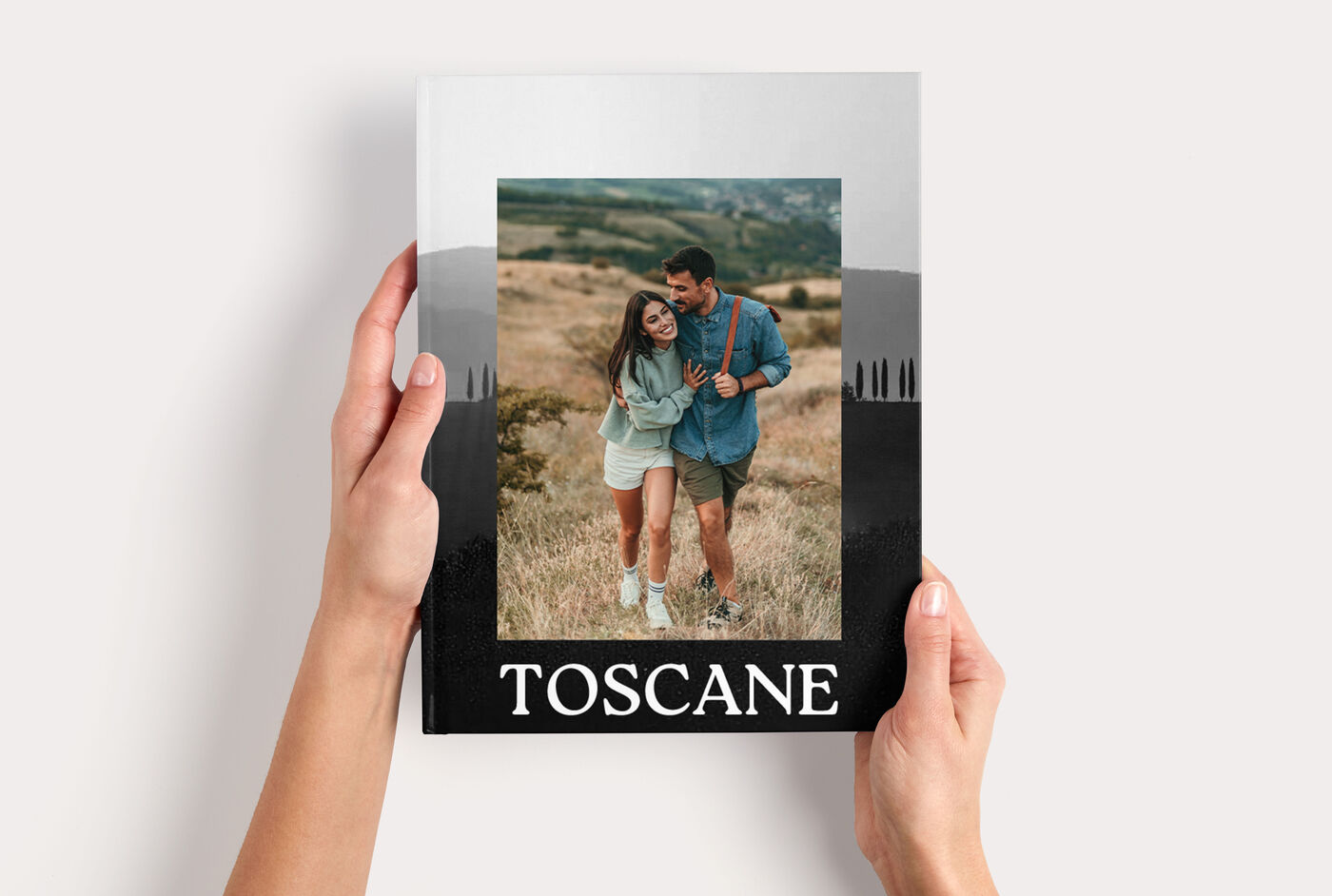 Fotoboek Large Staand met een foto van een stel in Toscane, vastgehouden door twee handen.