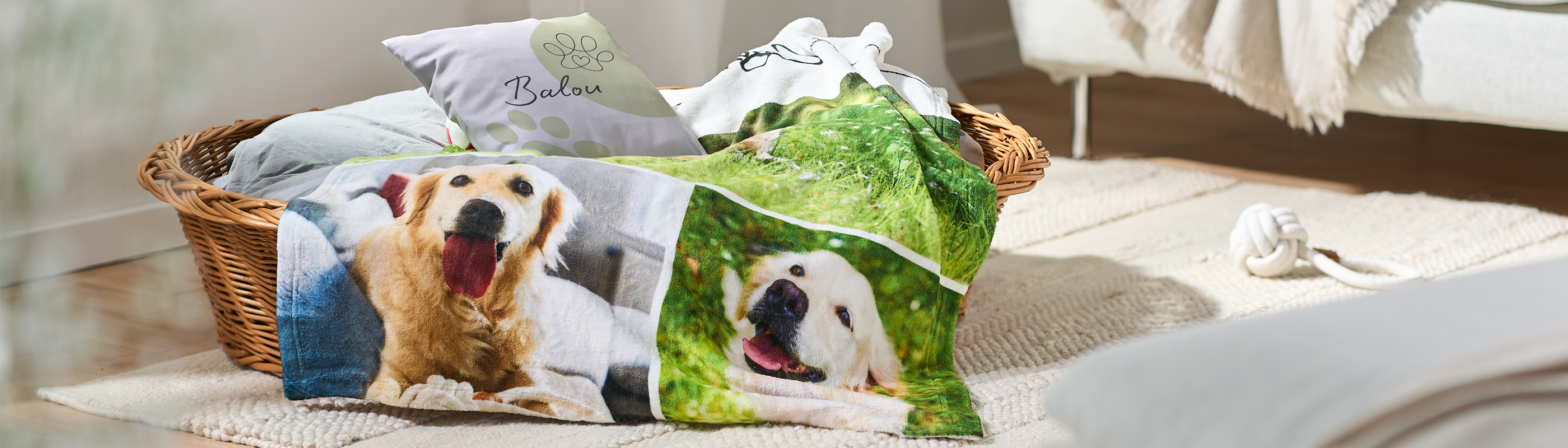 Een hondenmand met kussens en een hondendeken met foto's en de naam van een hond