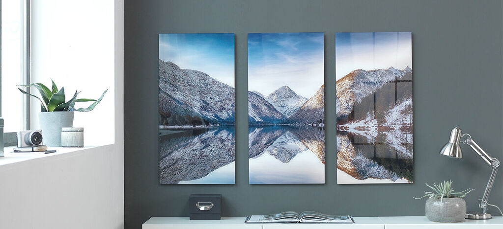 Drie mooie foto's van besneeuwde bergen en een helder meer aan de muur
