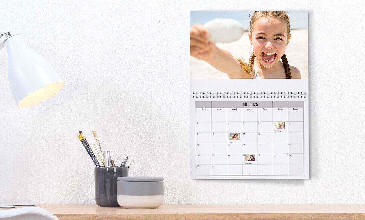 Een persoonlijke wandkalender met foto's en notities voor juli 2023.