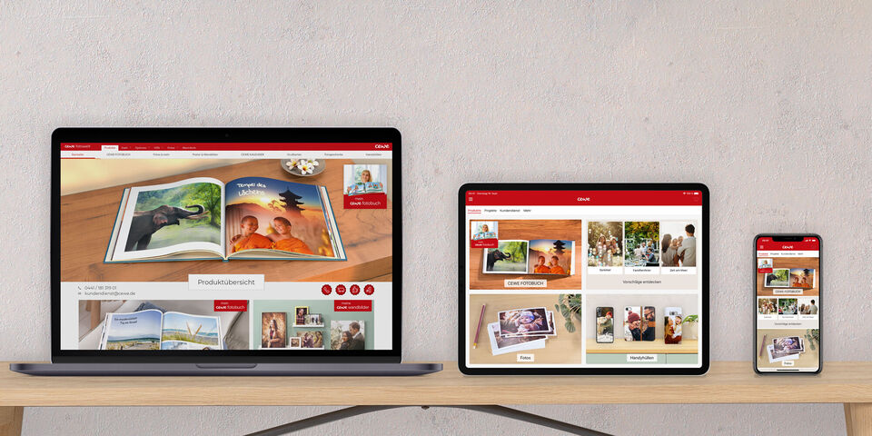 Drie apparaten tonen de CEWE fotoboek website: een laptop, tablet en smartphone met familieherinneringen.