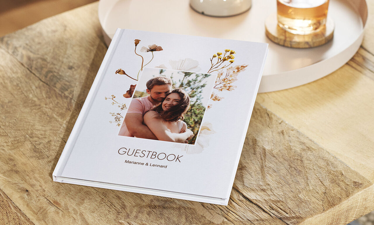 Een liefdevol vormgegeven gastenboek op een houten tafelblad.