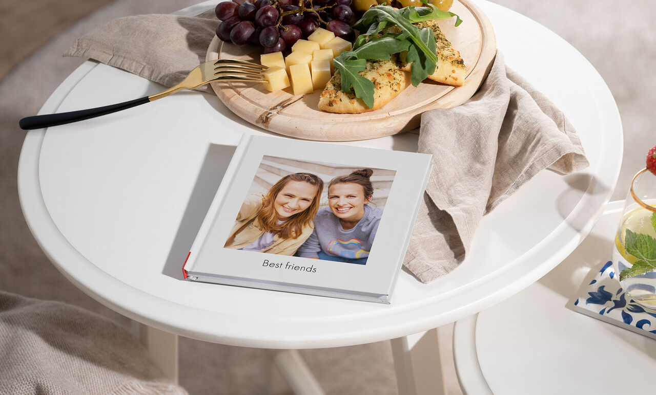 Een zorgvuldig ontworpen fotoboek met de titel 'Best friends', omringd door fruit en snacks.