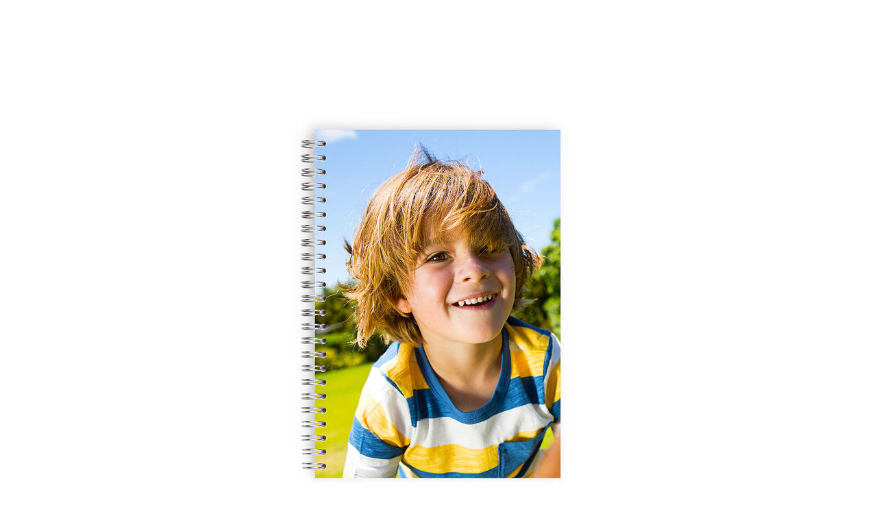 Blij kind met een persoonlijk notitieboekje in de natuur.