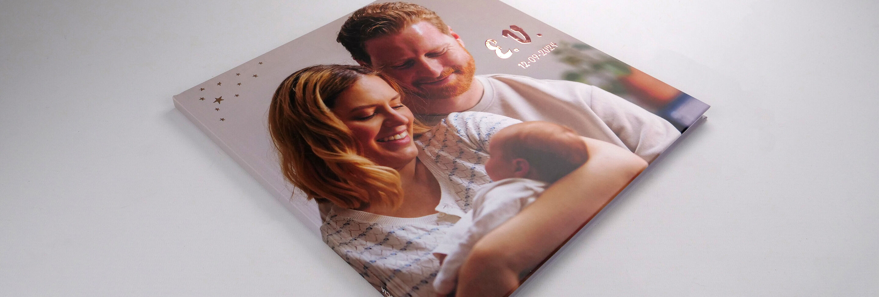 Het CEWE FOTOVBOEK toont een gelukkig gezin met een baby.
