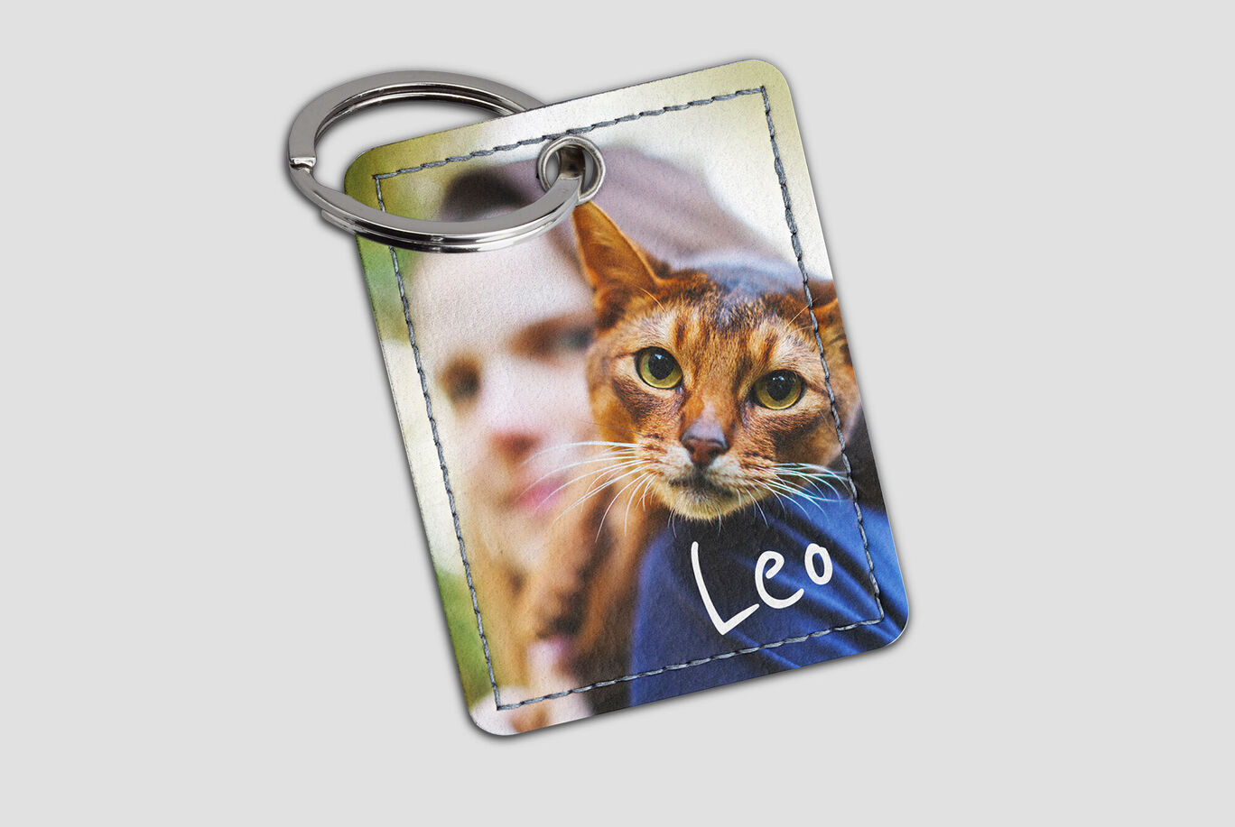Persoon met kat op een sleutelhanger, naam Leo zichtbaar