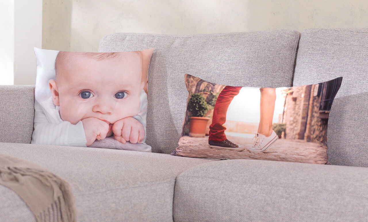 Een gezellige woonkamer met twee decoratieve kussens op een grijze bank, één met een kussend paar.