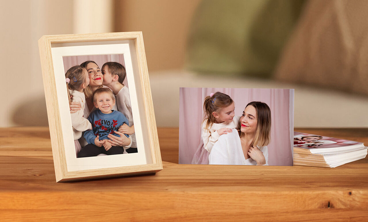 Twee ingelijste foto's met lachende kinderen en een vrouw op een houten tafel in een gezellige kamer.