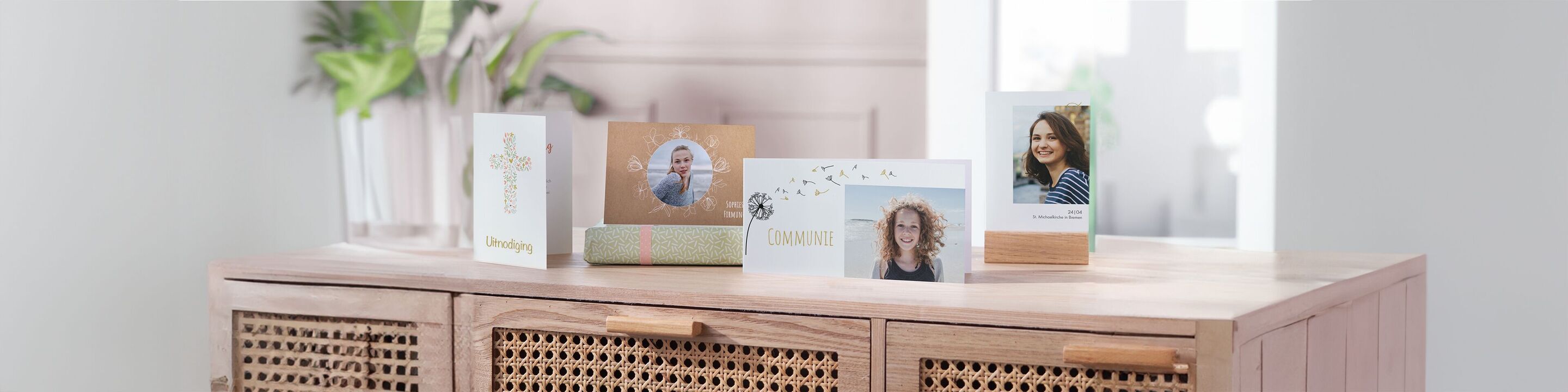 Vijf liefdevol ontworpen CEWE wenskaarten met foto's staan op een lichte commode.
