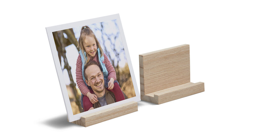 Een ingelijste foto van een gelukkig kind op een houten standaard.